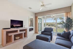 Living room opening to a screened lanai with lake views in a Naples vacation rental