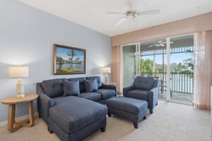 Living room with screened lanai access and a lake view in a Naples vacation rental