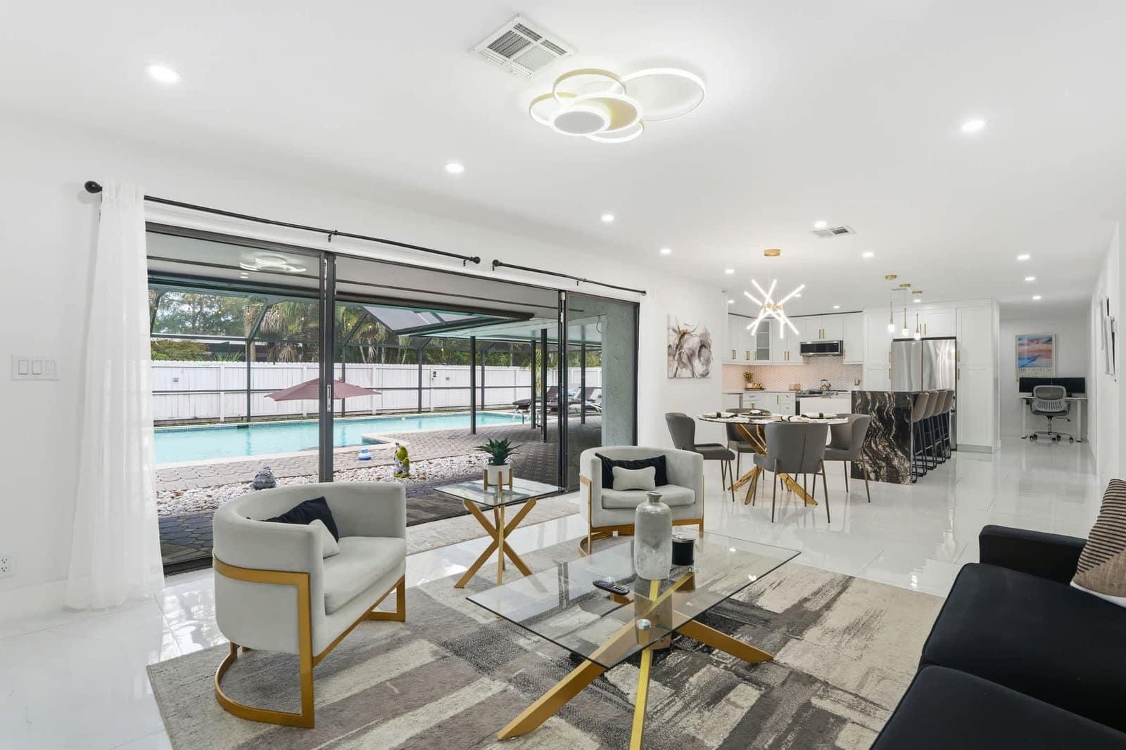 Modern living and dining room with a pool view in a Naples vacation rental